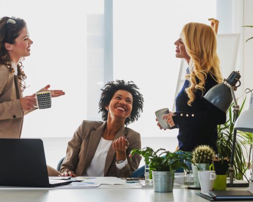Diverse group of smiling business women having a break in office